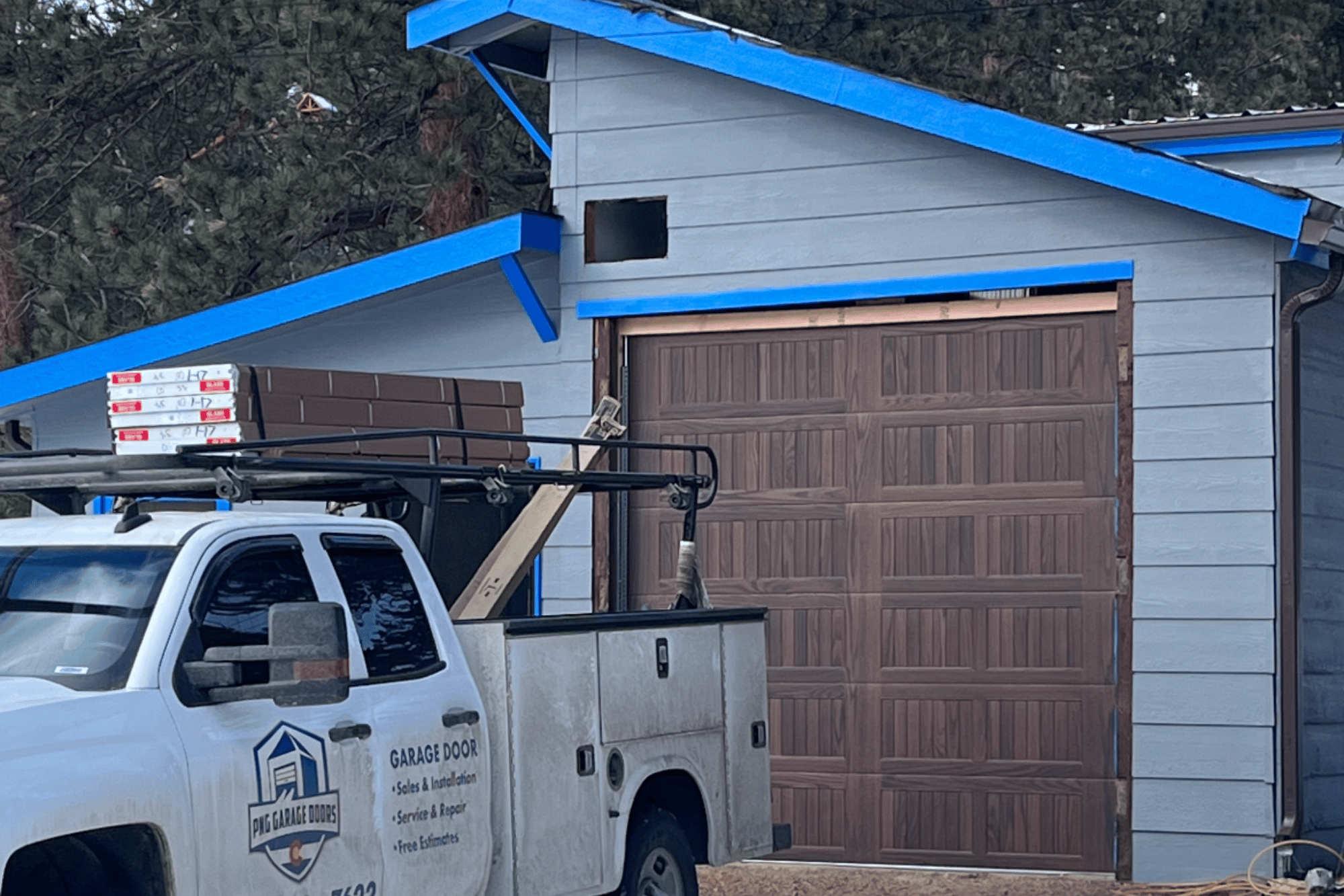 a new garage door replacement with a truck parked in front